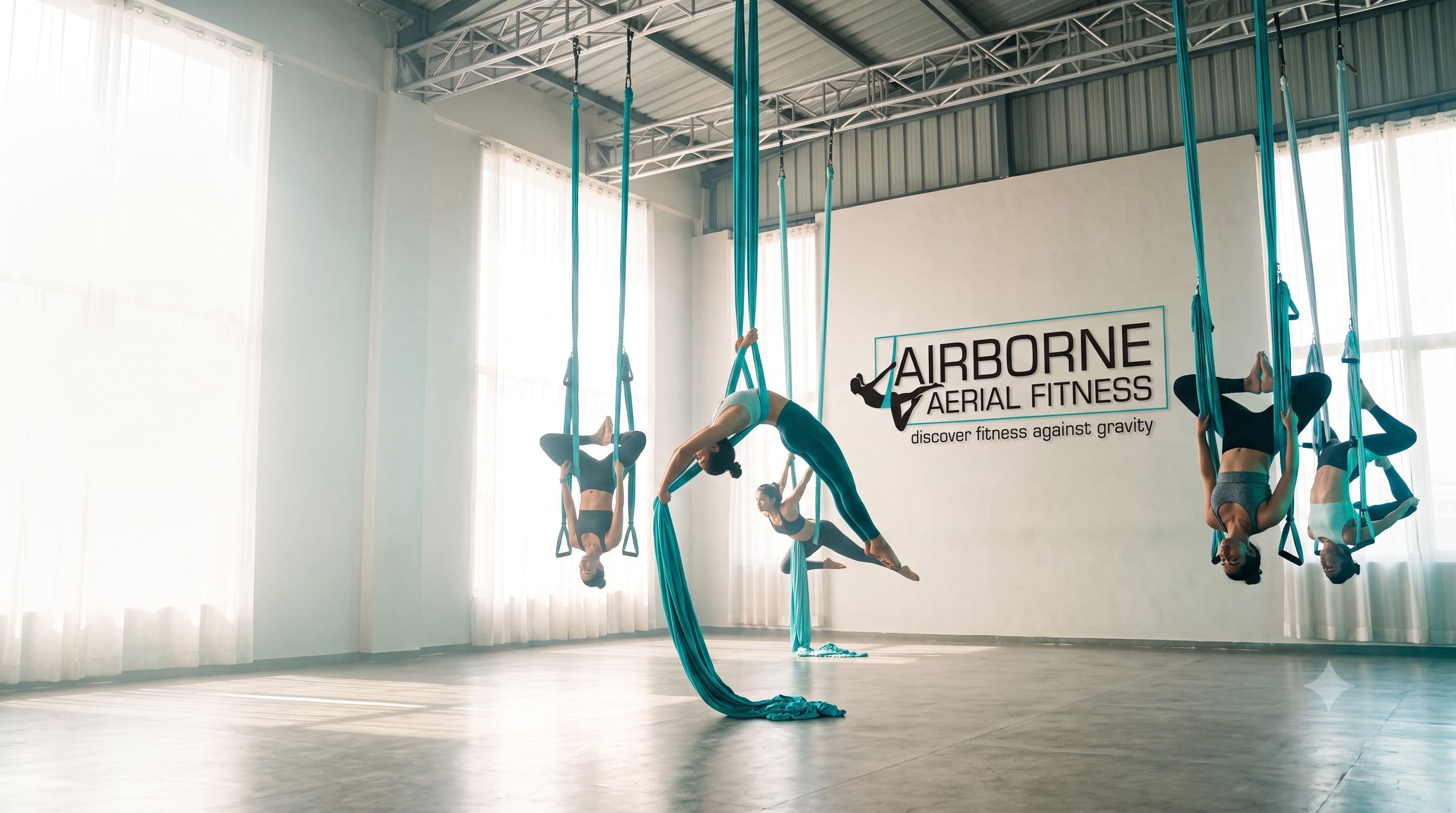 Airborne athletes mid-flow on aerial silks in a bright, airy studio, poised and powerful